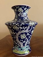 Front view of cobalt blue ceramic vase with floral patterns on a wooden surface.