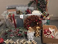 Wide view of the wrapping station showing assorted wrapping paper, ribbons, bows, wreaths, angel figurines, and box of decorations