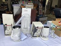 Two Dimensions Adjustable Accent Halogen Lights with wired plugs and boxes, alongside one unopened D3 Touch LED Table Lamp box.