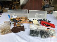 Wide view of various wooden-handled crafting tools, a bag with wire clips, a small red pouch, and other crafting accessories spread on a table.