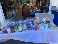 Wide view of lot arranged on white tablecloth with various fabric swatches, scissors, and sewing tools