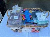 Full view of the basket containing fabric squares, batting, tools, and other quilting supplies