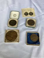 Four assorted medals including American War Medals and commemorative medals displayed on a fabric background.