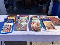 Image of 17 quilting books arranged on a table showing colorful covers and titles related to quilting techniques and patterns.