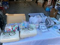 Wide shot of a table displaying various quilting pattern packets and two large rolls of cotton batting labeled Heirloom Premium Twin Size