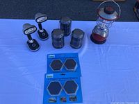 Four lights and two packs of furniture sliders displayed on white table