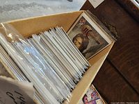 Full box of 140 comics in protective plastic sleeves, viewed from side angle showing the quantity and storage method.