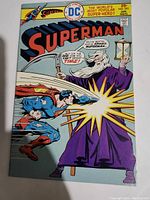Front cover of Superman No. 295 comic showing Superman battling a cloaked figure representing Time holding a scythe and hourglass.