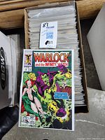 Box of approximately 130 vintage comic books in protective sleeves, featuring Warlock and the Infinity Watch, Issue #29 on top.