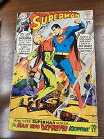 Front cover of Superman No. 205 comic showing Superman confronting a villain with dramatic text and a burning city background, priced at 12 cents, from April 1968.