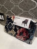 Floral chair cover fabric in original sealed plastic bag with a label showing an image of a chair with the fabric and brand name.