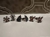 Photo showing four pairs of Christmas-themed cufflinks: snowflakes, two designs of Christmas trees, and Santa Claus figures.