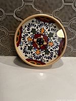 Front view of the Mexican decorative clock showing colorful tile-inspired pattern inside wooden frame.