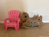 Toddler rocking horse and pink plastic lawn chair side by side against a wall