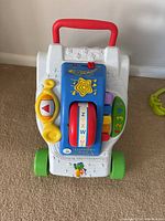 Front view of LeapFrog Learning Baby Walker showing red handle, interactive panel with spinning letter wheel, yellow phone handset, and colorful piano keys.
