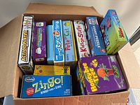 Box containing multiple kids board games with colorful packaging arranged inside