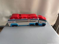 Red, white, and blue closed Paw Patroller toy truck with PAW Patrol logo on the side.