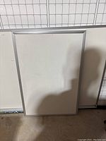 Full view of the rectangular white board with aluminum frame, showing the overall condition and size.