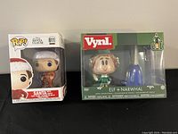 Funko Pop Santa Claus figure #611 with lights in box and Elf + Narwhal Vynl figures in box side by side.
