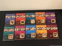 Photo showing all ten DVD cases of Friends seasons 1 through 10 laid out in two rows, each case featuring distinctive cover art with cast images and season numbers.