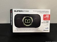 Front view of unopened Monster Superstar speaker box showing product image, branding, and key features such as World's Smallest Audiophile Speaker, Bluetooth connectivity.