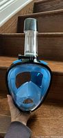 Front view of full face snorkel mask showing blue silicone skirt, clear face window, black frame, and attached snorkel with GoPro mount.