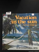 Front cover of the LP showing tropical beach with palm trees and album title and artist name.