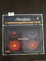 Front cover of Headpins 'Turn It Loud' vinyl LP showing amplifier and speaker design with band and album name.