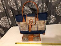 Front view of the woven tote bag and matching wallet set with a tape measure for size reference.