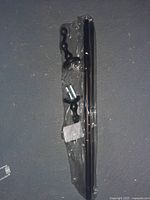 New double towel bar with oil rubbed bronze finish, packaged with mounting hardware in clear plastic wrapping.