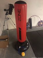 Photo of the red GoZone inflatable punching bag standing upright showing full height and black base with attached yellow foot pump.