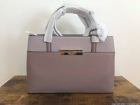 Front view of bag showing colorblock panels, handles wrapped in protective foam