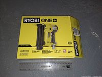 Closed retail box of Ryobi One+ 18V AirStrike Brad Nailer with specifications and branding visible.