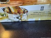 Box of stainless steel oval roaster showing brand logo and roasted chicken image