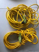 Two coiled yellow electrical cords labeled with lengths 20' and 40' placed on white surface.