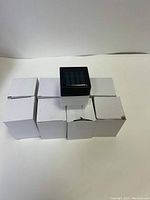 Photo of 8 solar light boxes arranged with one light outside the boxes.