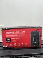 Photo of the CyberPower box front panel showing product name, power capacity (360 watts, 650 VA), battery backup time, and protection features.