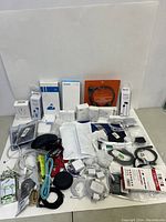 Wide view of all electronic accessories spread out showing various cables, earphones, adapters, mice, and boxes