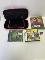 Photo of Nintendo Switch case, PlayStation game Track & Field 2000, Nintendo DS game The Simpsons Game, Xbox One game Red Dead Redemption II, and Nintendo Switch game cartridge Mario Party Superstars.