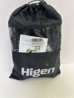 Expandable garden hose contained in a black fabric carry bag with drawstring and Higen brand name printed on exterior. Includes product label with barcode.