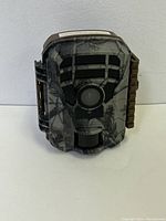 Front view of mini trail camera showing camo pattern, camera lens, and sensor lights