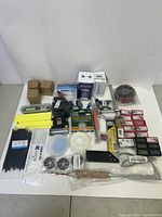 Full lot overview showing various untested new hardware tools and accessories neatly arranged on a white surface.