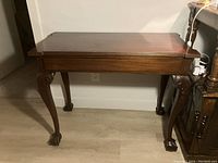 Front view of antique mahogany card desk showing overall condition and leg design.