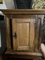 Front view of oak cupboard with panel door and iron handle