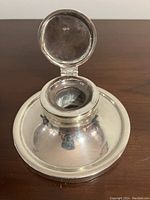 Opened sterling silver capstan inkwell showing interior and hinged lid