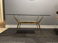 Full front view of mid-century modern brass and glass side table