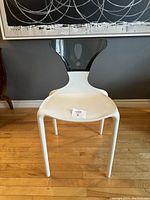 Front view of the postmodern accent chair showing the black lucite backrest and white seat