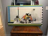 Full view of the screen print artwork depicting soccer players running and a ball.