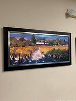 Rectangular framed painting of vineyard with autumn colors, pathway, and building.