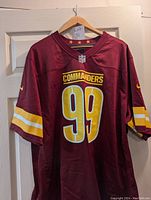 Front view of a burgundy Washington Commanders football jersey with yellow number 99 and COMMANDERS text.